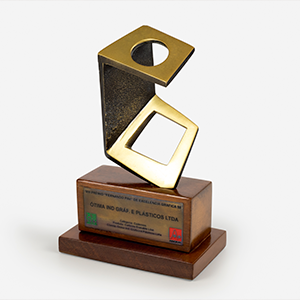 Na imagem, há a fotografia do troféu que a Ótima Gráfica recebeu no VIII Prêmio Fernando Pini de Excelência Gráfica.